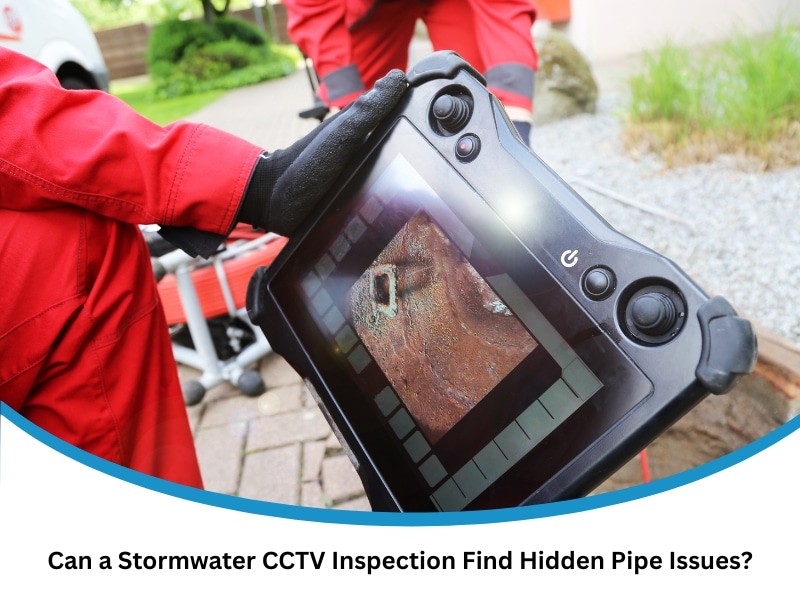 Worker holding a monitor showing pipe footage captured during a stormwater CCTV inspection.